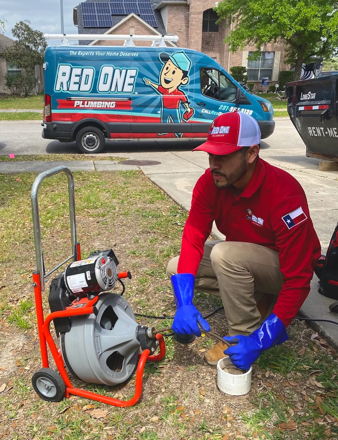 Red One Plumbing Technician performing a drain cleaning service